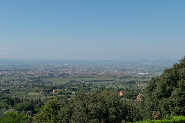 Awe-inspiring panorama from the valley's edge, offering a glimpse of Rome's suburbs under the radiant sun and endless sky
