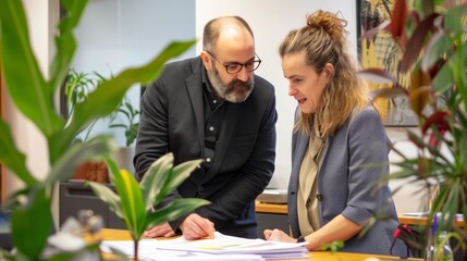Office strategy session featuring a focused male and female coworker analyzing notes on a board, representing effective teamwork.