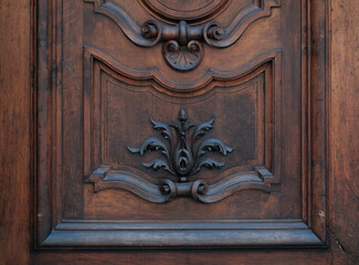 Close up of a brown hardwood home door with a creative arts carving pattern