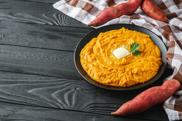 delicious mashed sweet potatoes on a black wooden rustic background