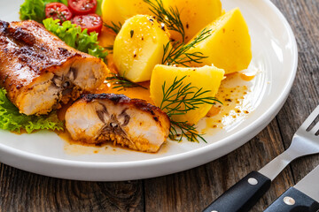 Baked rabbit saddle and vegetable salad on wooden table
