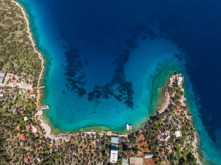 An aerial view of Limanagzi Beach in Kas, Antalya, Turkey, showcasing the turquoise sea, coastline, and surrounding nature from above.