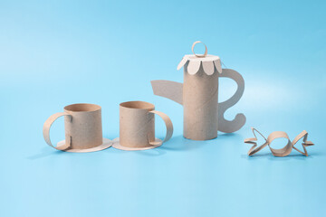 Colorless paper craft, teapot and cups for a doll tea party, embodying recycling concepts. Ideal...