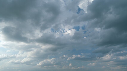 Obraz premium Dramatic sky with gray dark clouds before rain. Powerful cumulus clouds with a dark base. Timelapse.