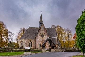Fototapeta na wymiar Luss parish Church of Scotland in a colorful cloudy autumn day