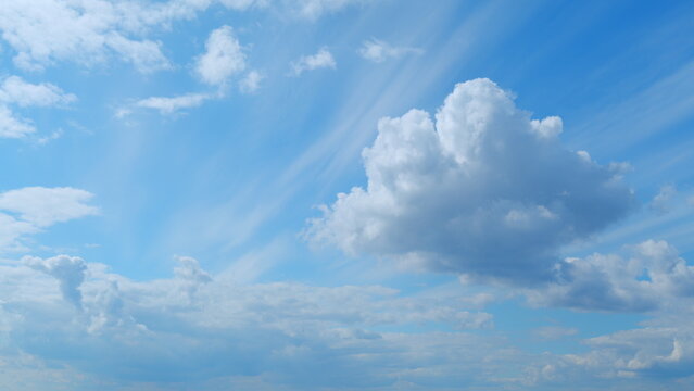 Dramatic moving white cumulus and cirrocumulus clouds or puffy fluffy cloudscape on beautiful sunny blue sky. Time lapse.