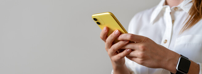 Online messaging. E-commerce and electronic banking. Golden coloured mobile phone in hands of...