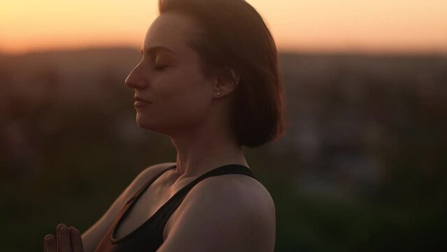 Portrait of confident young woman looking ahead and exhaling fresh air taking deep breath and reducing stress after work at sunset Successful beautiful female resting for peaceful mind outdoors