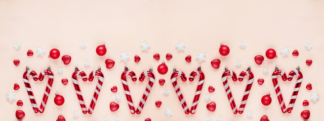 Christmas themed arrangement with candy canes, pink balls, star decorations pastel pink background