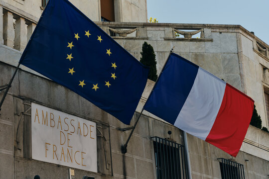 Belgrade, Serbia- 04.28.2024. The exterior of the French embassy in Belgrade, with the French flag and European Union flag above the door. Gold Letters Engraved in to White Marble Stone.