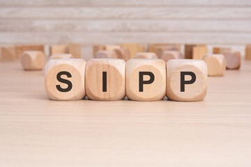 the word SIPP is elegantly displayed on a beige hardwood rectangle block