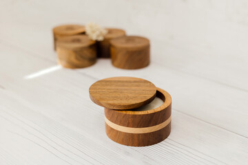 A candle in a wooden box. A candle on a white table.