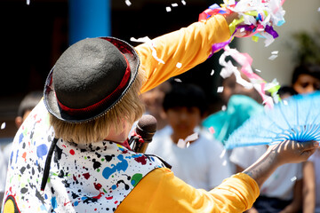 Back of a clown while giving a show for children at a party.