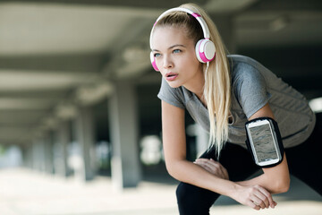 Active young woman working out with headphones outside