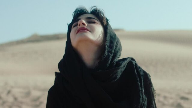 A Woman in hijab in the desert screaming for help