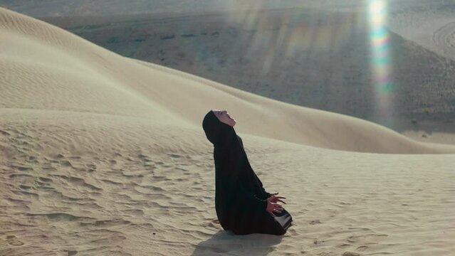 A Woman in hijab in the desert screaming