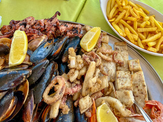 Seafood platter with musselspus, squid, squidpus and French fries a Marsaxlokk cafe, Malta