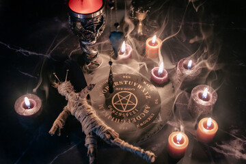 A haunting occult setup featuring a pendulum, mystical symbols, candles, a voodoo doll, and a...