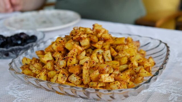 Spicy French fries are served. French fries for breakfast. French fries placed on a plate. Delicious French fries on the breakfast table. spoon some of the fries onto his own plate. Serving food to yo