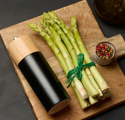 Fresh green asparagus sprouts on a black wooden background. View from above