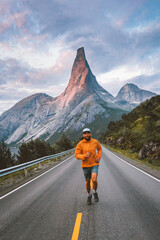 Man running in mountains asphalt road in Norway travel active healthy lifestyle outdoor adventure...