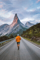 Man running on mountain road in Norway travel adventure active healthy lifestyle outdoor summer vacations motivation sport freedom escape concept Stetind peak view