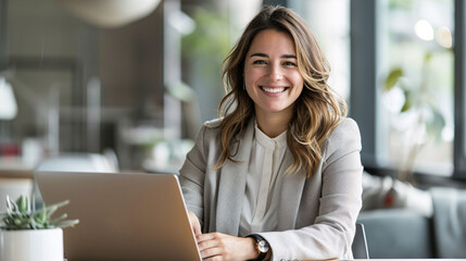 portrait of smiling business woman sitting at desk with computer laptop