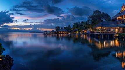Obraz premium The panoramic twilight scenery of an exotic waterfront resort with traditional architecture