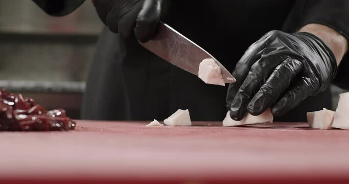 Close-up chef chops sheep tail fat on a cutting board to prepare liver kebab. Oriental cuisine