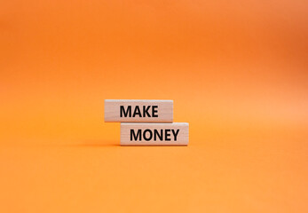 Make Money symbol. Wooden blocks with words Make Money. Beautiful orange background. Business and...