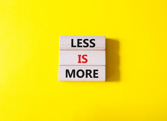 Less is More symbol. Concept words Less is More on wooden blocks. Beautiful yellow background. Business and Less is More concept. Copy space.