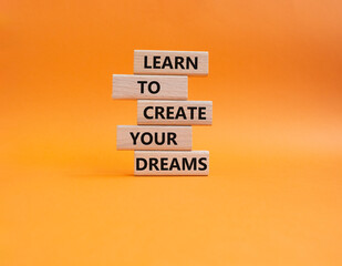 Dreams symbol. Concept words Learn to create your Dreams on wooden blocks. Beautiful orange background. Business and Learn to create your Dreams concept. Copy space.