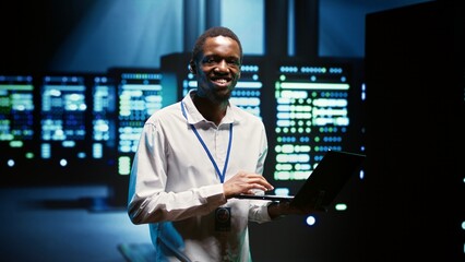 Technician making sure high tech facility data servers are appropriately equipped to provide redundancy, automatic failover and rapid reconfiguration of clusters to minimize failure of individual rigs