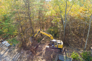 To prepare land for construction, trees were uprooted with an excavator tractor in order to make...