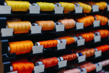 amount of different skeins of threads on special shelves in sewing studio or atelier, several...