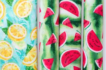 various rolled fruit-themed cloth pieces featuring lemons and limes and floating watermelon slices