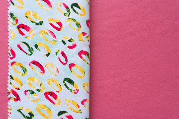 simple folded decorative fabric swatch with zigzag edge on pink paper with space for copy