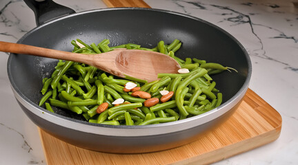 A vibrant scene of healthy meal preparation. Green beans and almonds sauté in a pan, stirred by a wooden spoon