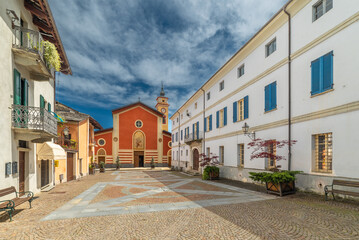 Sanfront, Cuneo, Italy - May 03, 2024: Piazza Ferrero paved with porphyry and stone slabs with the parish church of San Martino