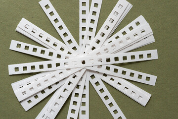 radial shape composed of many coil binding spine strips on rough green paper