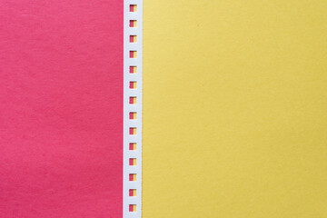 red and yellow construction paper with a single white paper binding strip