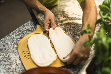 closeup of hands preparing dough on a board to make pizza. High quality photo