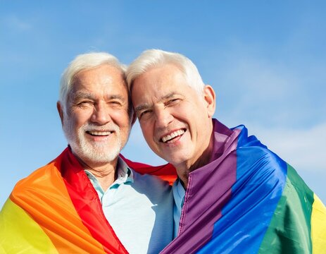 Gl&uuml;ckliches gleichgeschlechtliches Paar. &Auml;lteres schwules Paar in einer Regenbogenfahne eingeh&uuml;llt.