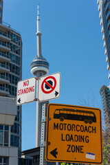Obraz premium Motorcoach Loading Zone and other traffic signs in downtown Toronto, Canada (with view of CN Tower behind)