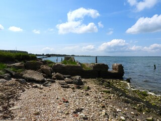 View of the bay with sailboats and the shore with concrete elements
