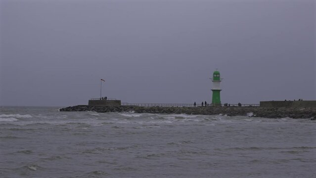 Entrance to harbor of Rostock on baltic sea. Lighthouse Molenfeuer Westmole, Warnemunde, Rostock, Mecklenburg-Vorpommern, Germany. Gruner Leuchtturm Warnemunde in Rostock Deutschland. 