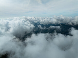 Aerial view flowing fog waves on mountains tropical rainforest,Bird eye view image over the clouds,...