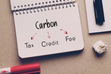 Understanding the difference between Carbon Tax, credit and fee concept on notepad. Government...
