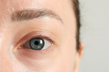 Closeup photo of woman with beautiful eyes on light background