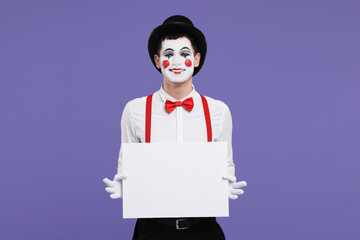 Funny mime artist with blank sign on purple background